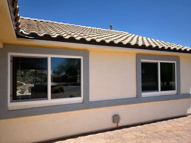 Completed sliding window replacements, tan stucco home